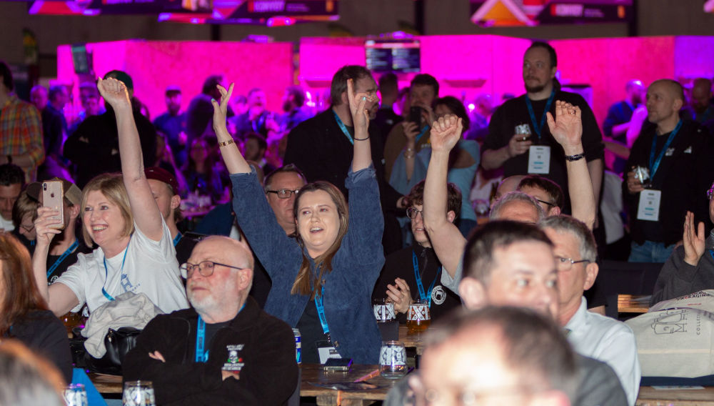 Three people raising their arms joyfully in a crowded room at the SIBA Competition 2024 (Photo: Society of Independent Brewers)