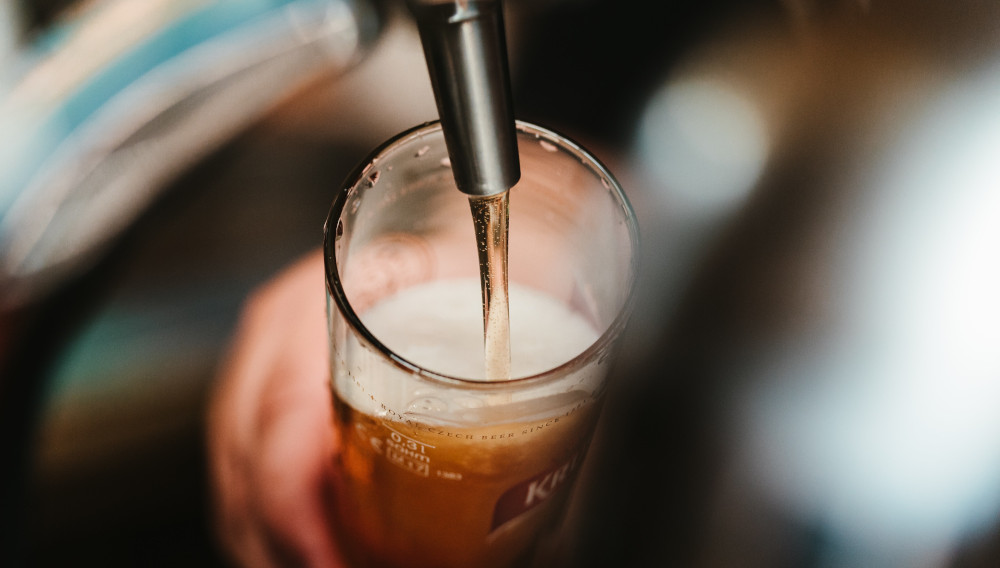 Bier fließt aus einem Zapfhahn in ein Bierglas (Bence Boros auf Unsplash)