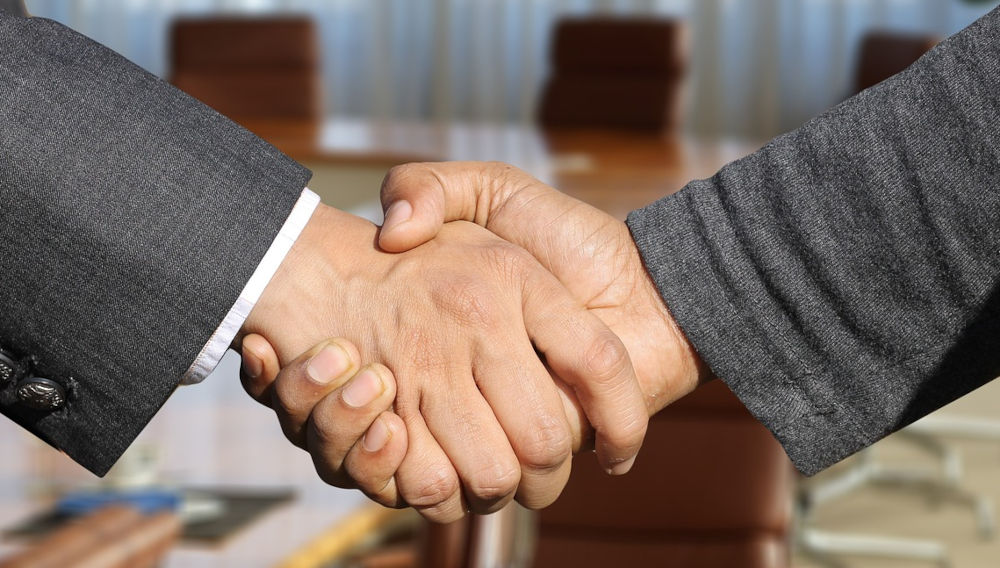 Two people in business attire shaking hands, close-up (Photo: Gerd Altmann on Pixabay)