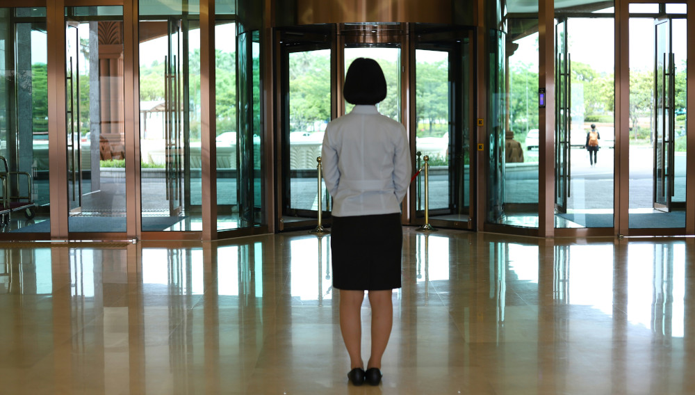Frau steht in einer Lobby (Foto: Nagesh Badu auf Unsplash)