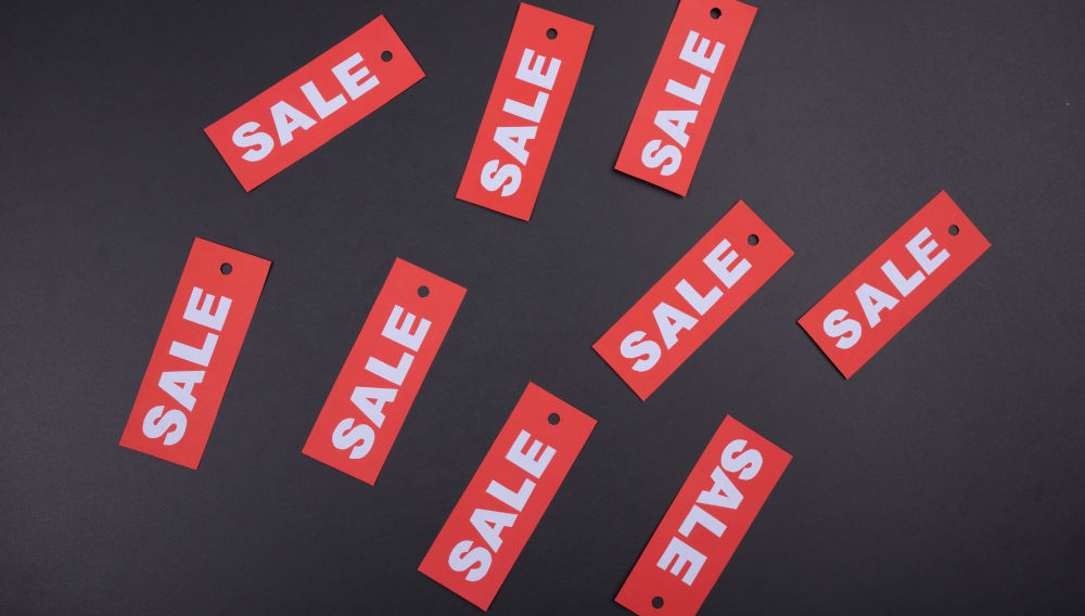 Several small red paper strips labelled “Sale” (Photo: Tamanna Rumee on Unsplash)