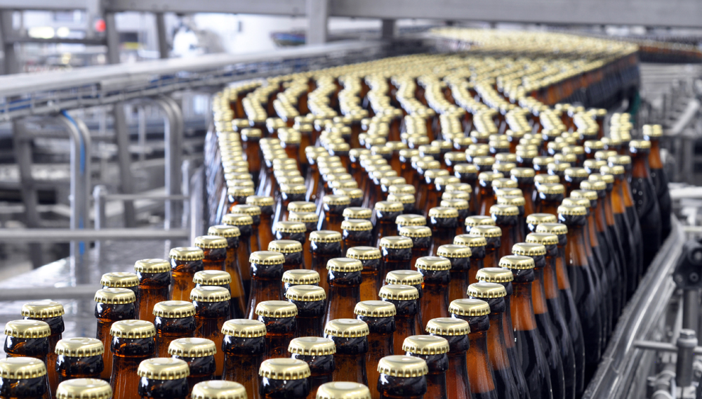 Gezielte Bekämpfung von Biofilmen im Flaschenpasteur sorgt nicht nur für bessere hygienische Bedingungen Bierflaschen auf Transportband im Flaschenkeller