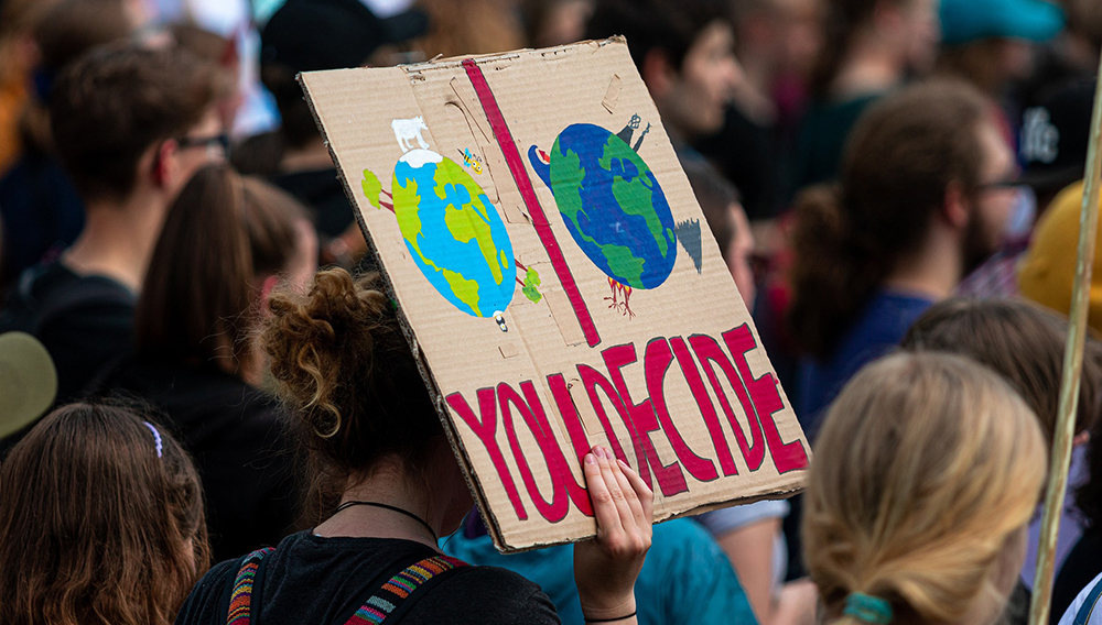 Im Privatbereich darf jeder seine (politische) Meinung öffentlich kundtun, allerdings darf kein Bezug zum Arbeitgeber hergestellt werden (Foto: Dominic Wunderlich auf Pixabay) Demonstranten mit einem Schild (Foto: Dominic Wunderlich auf Pixabay)