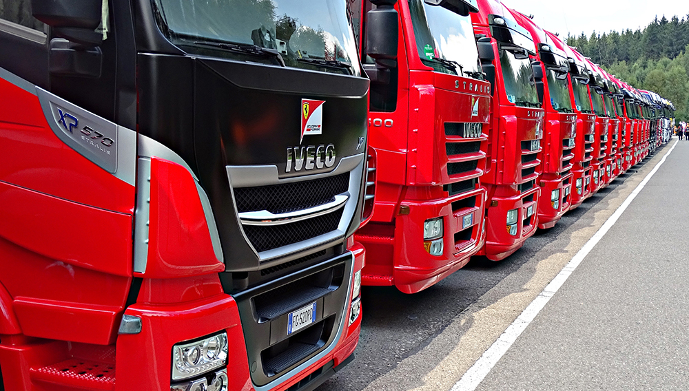 LKW im Fern- und Regionalverkehr tragen deutlich zu den CO2-Emissionen bei Eine Reihe von geparkten, roten LKW
