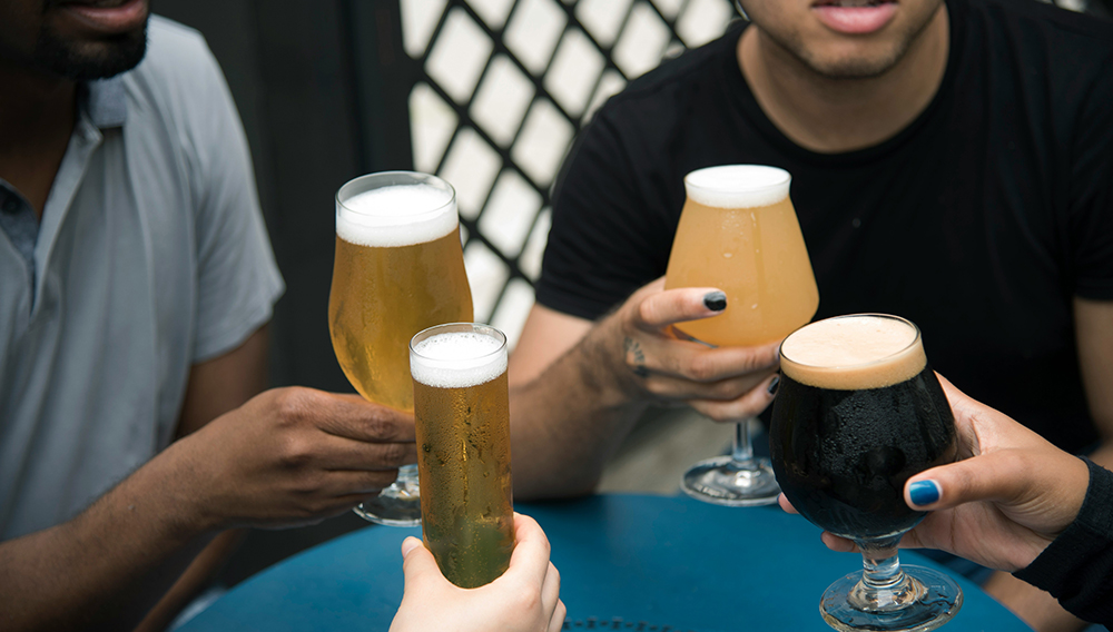 Hände halten Biergläser mit verschiedenen Biere (Foto: Elevate auf Unsplash)
