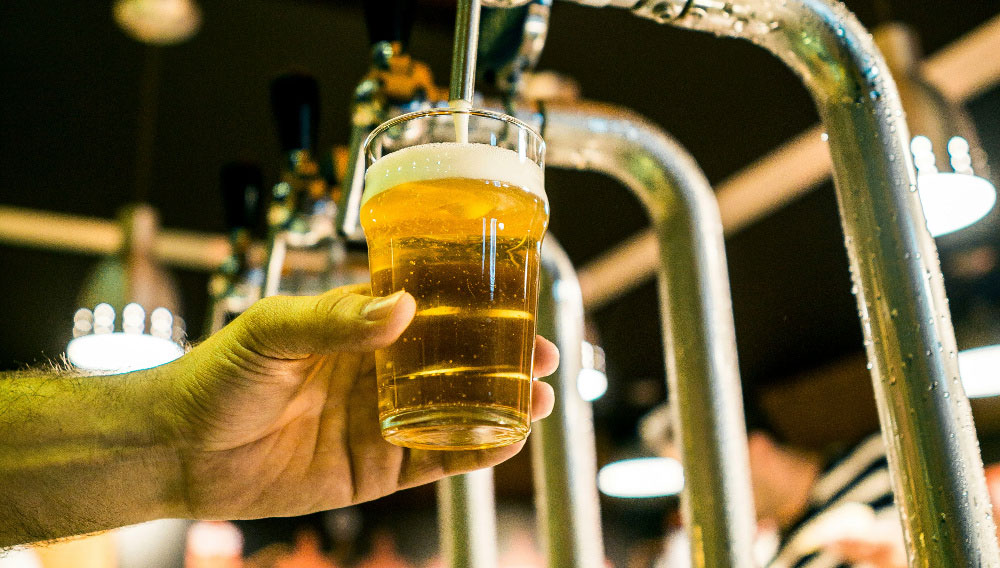 Ein Bierglas wird an einem Zapfhahn gefüllt (Foto: Fabio Alves auf Unsplash)