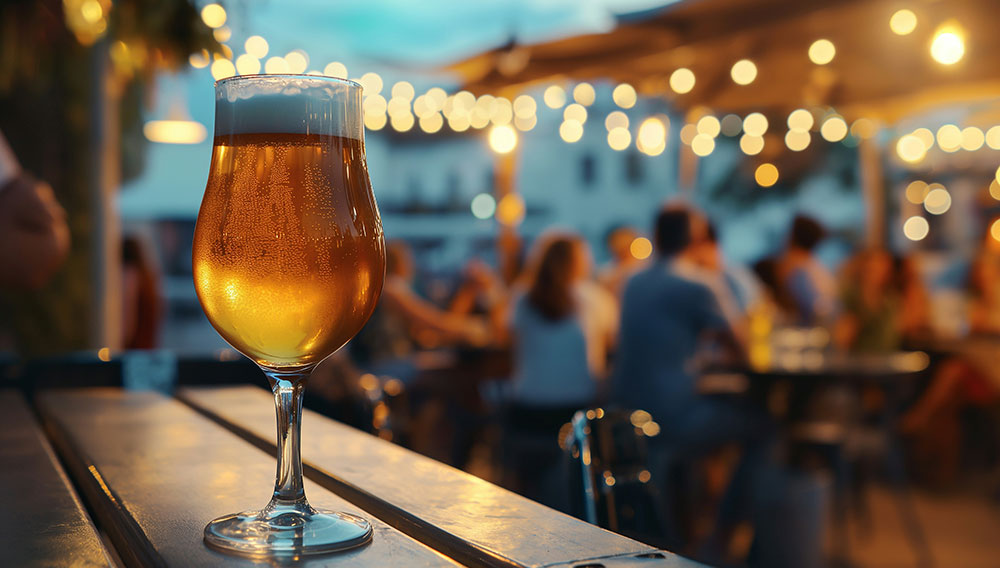 Bierglas auf einem Tisch im Außenbereich einer Gastronomie (Foto: Chips & Champagner auf Unsplash)
