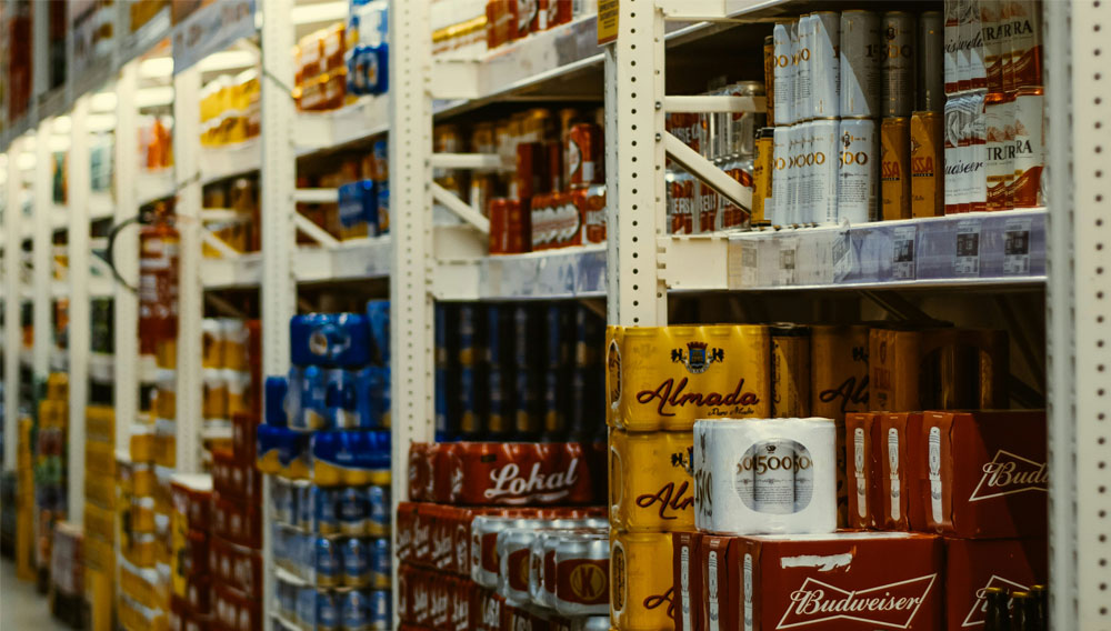 Die Unternehmen bewerteten den Blick in die Zukunft deutlich positiver, als es das eigene Geschäftsergebnis vermuten lässt Getränkelager mit Hochregalen und Paletten (Foto: Eduarde Soares auf Unsplash)