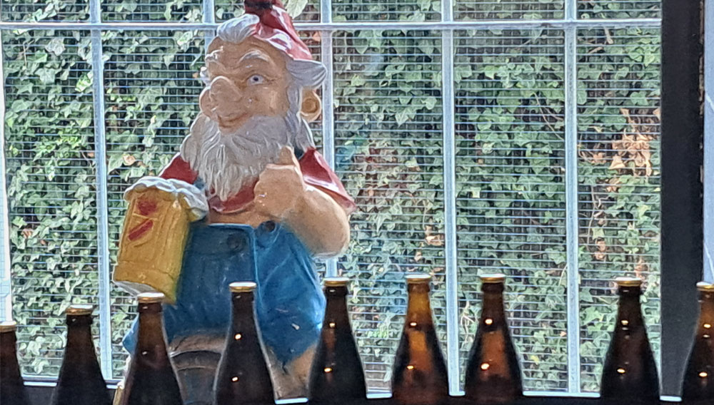 Zwerg der Brauerei Fässla in Bamberg hinter Bierflaschen