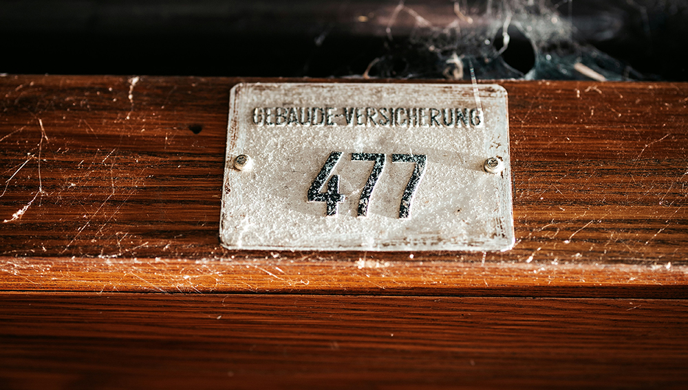 Smarte Sensortechnologien in Verbindung mit modernen Netzwerken haben das Potential, die Zusammenarbeit mit Versicherern grundlegend zu verändern [(Foto: Samuel Svec auf Unsplash) An einem Balken montiertes Schild mit der Aufschrift Gebäudeversicherung 477