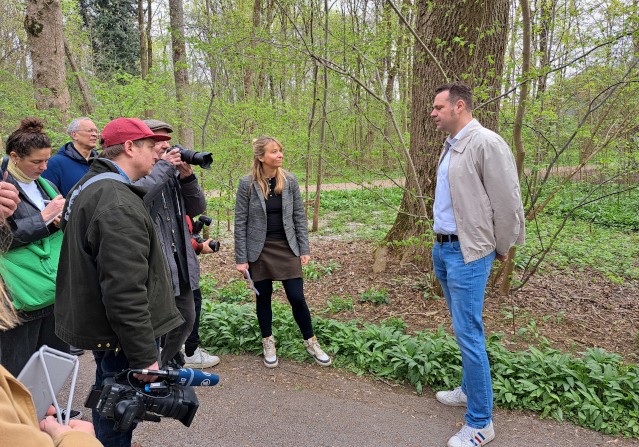 Mathias Hutzler und Vertreter der Presse vor einer Esche in den Münchner Isarauen