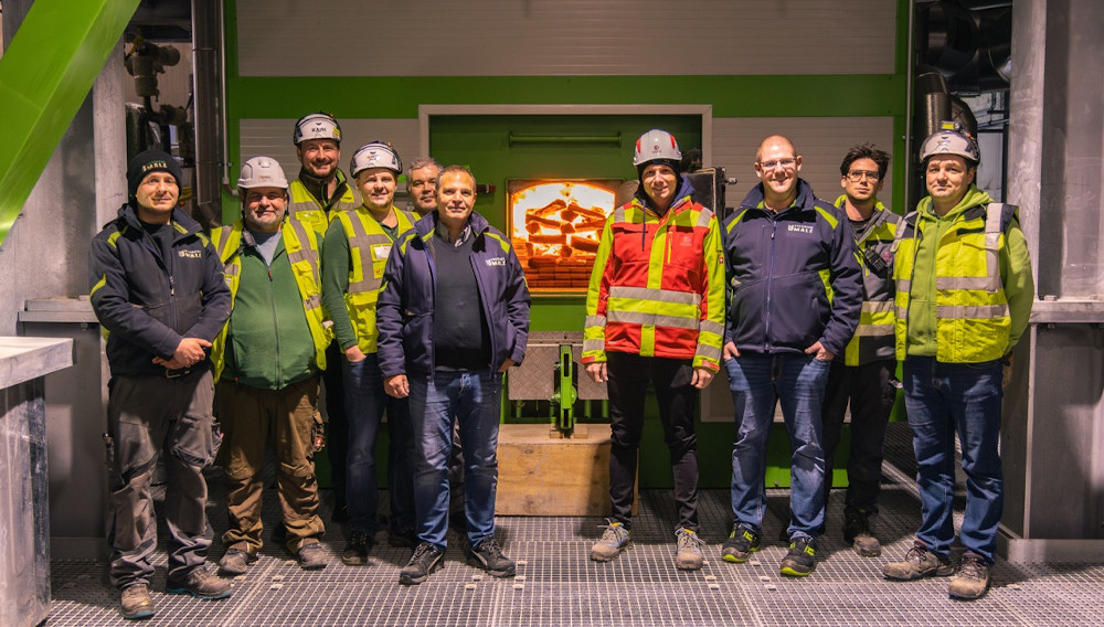 Kunde und Projektteam vor der Biomassefeuerung Mehrere Personen vor der Biomassefeuerung bei Avangard Malz