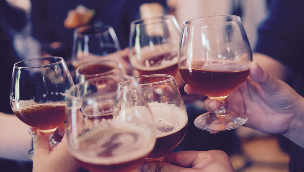 Hände halten Biergläser (Foto: Yutacar auf Unsplash)